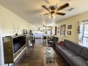 ein Wohnzimmer mit Couch und Flachbildfernseher in der Unterkunft The 1950s Retro Riverside Cottage in Dardanelle