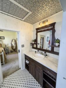 ein Badezimmer mit Waschbecken und Spiegel in der Unterkunft The 1950s Retro Riverside Cottage in Dardanelle + 20 Fotos