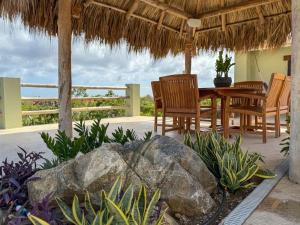 ノールトにあるPoolside Escape Menas Authentic Wellness Ecoのパティオ(テーブル、椅子、大きな岩付)