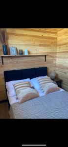 a bed with pillows on it in a room at Domki Rewal kalimera-sun in Rewal