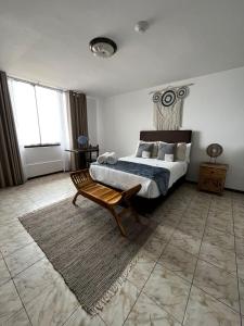 a bedroom with a bed and a bench in it at Hostal Brisas del Mar in Punta Negra +61 photos