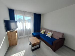 a living room with a couch and a tv at Akwarium in Międzywodzie