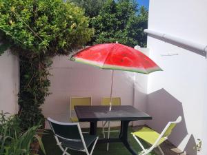 a black table with a red umbrella and chairs at Sara's Home 24 in Rouen