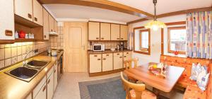 una cucina con un tavolo di legno e una sala da pranzo di Appart Mox a Tux