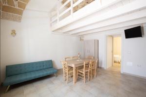una sala da pranzo con un tavolo e un divano verde di Dimore Salentine a Felline