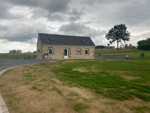 a stone house in a field with a grass yard at La maison à Nono in La Trinité