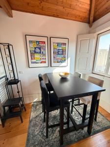 a dining room with a black table and chairs at Galeria 99 in Porto