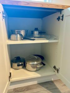 un armario con ollas y sartenes. en Bridgewater downtown apartment, en Bridgewater