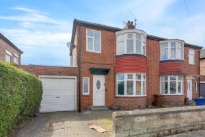 una casa de ladrillo rojo con garaje blanco en Luxury 5-bedroom home in Newcastle, en Longbenton