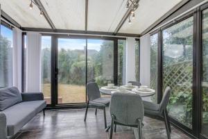 Un comedor con mesa y sillas y ventanas. en Luxury 5-bedroom home in Newcastle, en Longbenton