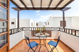 een balkon met een tafel en stoelen bij El Nido Seafront Hideaway by Bayside in Playa Honda