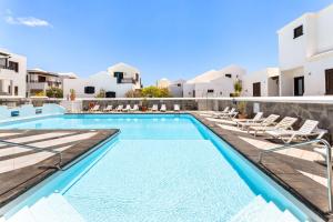 een zwembad in een villa met witte gebouwen bij El Nido Seafront Hideaway by Bayside in Playa Honda