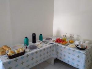 a table with a buffet of food on it at Oluap Pousada Mairiporã in Mairiporã