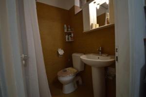 a small bathroom with a toilet and a sink at Avlonari Evias flat in the Central Square in Avlonárion