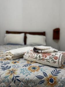 a bed with towels and pillows on it at Toca Da Onça Suítes in Lençóis