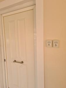 a white door with two switches on the wall at IVory Suites near Athens Airport in Spáta