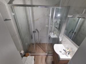 a bathroom with a shower and a sink at IVory Suites near Athens Airport in Spáta