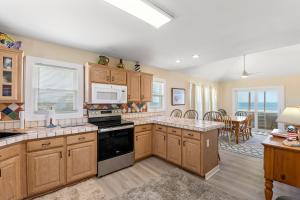 a kitchen with wooden cabinets and a dining room at Everlasting Moon in Rodanthe