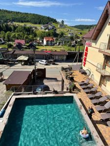 una persona seduta in una piscina in un hotel di Villa Anet a Bukovel