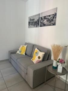 a living room with a gray couch and a table at Una Finestra tra i Vicoli - appartamento nel cuore di Vasto in Vasto