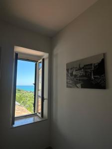 a room with a window and a picture of the ocean at Una Finestra tra i Vicoli - appartamento nel cuore di Vasto in Vasto
