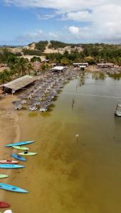 a beach with chairs and surfboards in the water at Riviera dourada - Casa Pôr do Sol in Jacumã