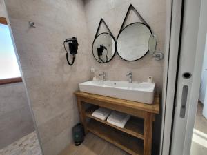 a bathroom with a sink and two mirrors on the wall at La grange d'augustin in Saint-Thibéry +13 photos