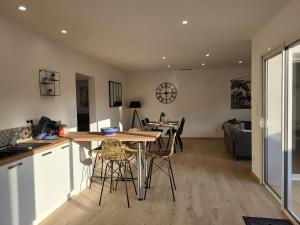 a kitchen and living room with a table and chairs at La grange d'augustin in Saint-Thibéry