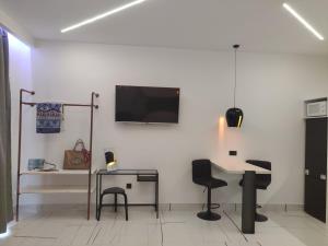 a room with a table and chairs and a tv on a wall at Roxanne Mini Suite With Yard in Melíssia