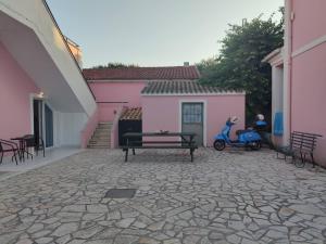 a scooter parked next to a bench in a courtyard at Roxanne Mini Suite With Yard in Melíssia
