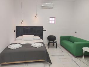 a bedroom with a bed and a green couch at Roxanne Mini Suite With Yard in Melíssia