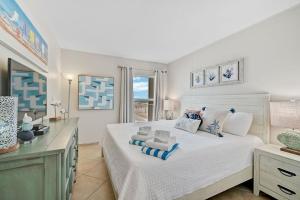 Siesta KeyにあるCondo 206の大きな白いベッドと机のある寝室