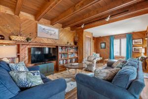 a living room with blue couches and a tv at Fiddlin Around in Duck