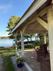 a covered patio with chairs and a view of the water at Dom nad jeziorem in Lutry