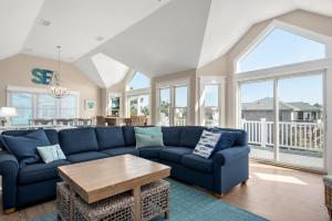 a living room with a blue couch and a table at Fish Tank in Corolla