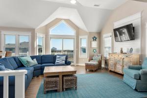 a living room with a blue couch and chairs at Fish Tank in Corolla