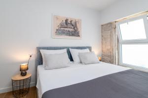 Un dormitorio con una cama blanca y una ventana. en Andreis Luxury Retreat, en Trogir