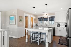 a kitchen with white cabinets and a large island at Fish Tank in Corolla