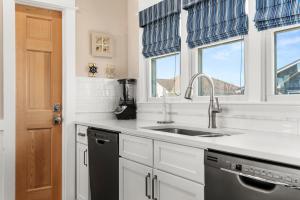 a kitchen with a sink and two windows at Fish Tank in Corolla