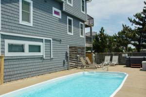 a swimming pool in front of a house at Fish Tank in Corolla +31 photos