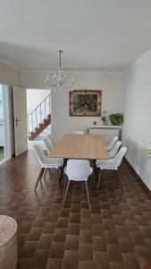 a dining room with a wooden table and white chairs at Sea Home in Middelkerke