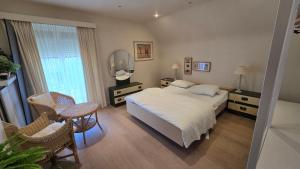 a bedroom with a white bed and a mirror at Sea Home in Middelkerke