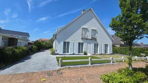 a white house with a fence in front of it at Sea Home in Middelkerke