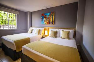 a hotel room with two beds and a window at Hotel Los Altos Express "La Centroamerica" in Managua +72 photos