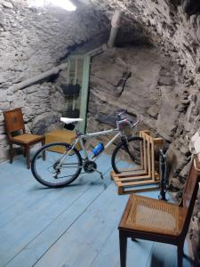 - un vélo garé dans une pièce avec une table et des chaises dans l'établissement sax & rosa, à Pigna