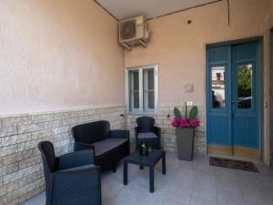 a patio with chairs and tables and a blue door at Nonna Palmina in Crispiano
