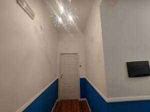 a hallway with a door and a chandelier at B&B mirò e appartamenti in Marina di Gioiosa Ionica