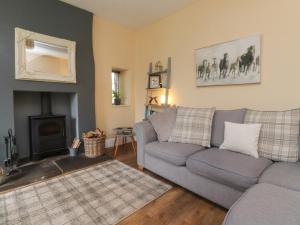 a living room with a couch and a fireplace at Glebe Cottage in Skipton
