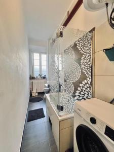 y baño con ducha y lavadora. en Sea view apartment Matulji, en Matulji