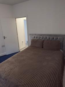 a bedroom with a bed with a striped bedspread at Central Wigan Stay in Wigan